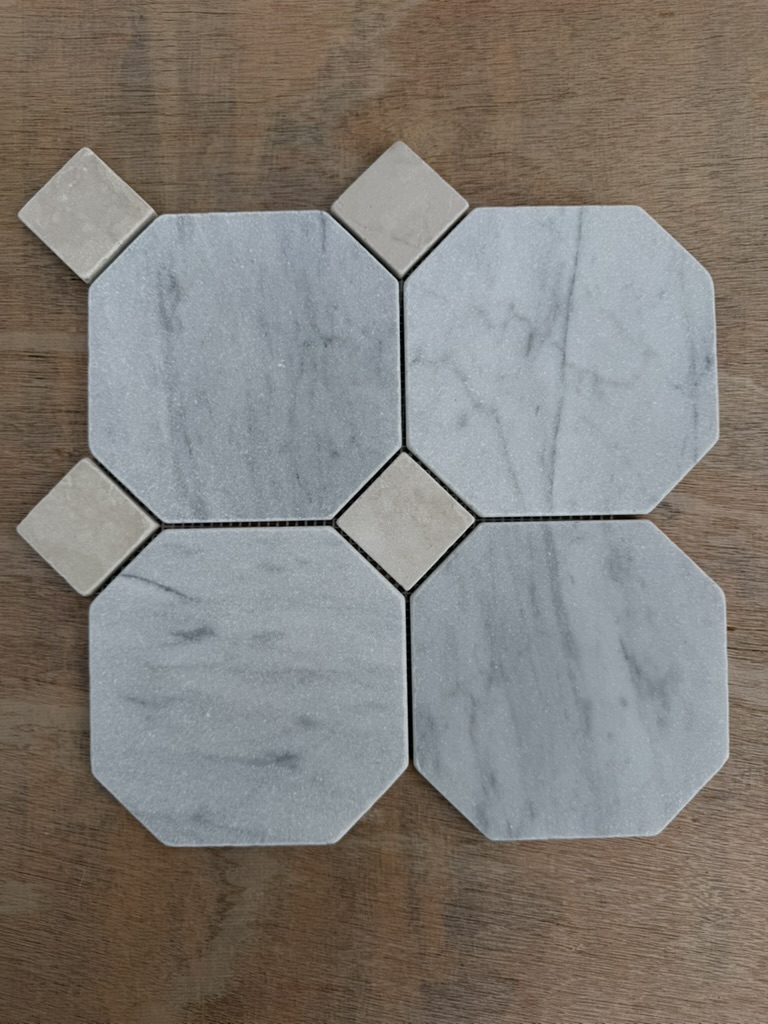 Marmorfliser Ottagono Carrara med lett trumlet antikk overflate og beige Botticino tosetter, for en varmere take på det tradisjonelle italienske gulvet.