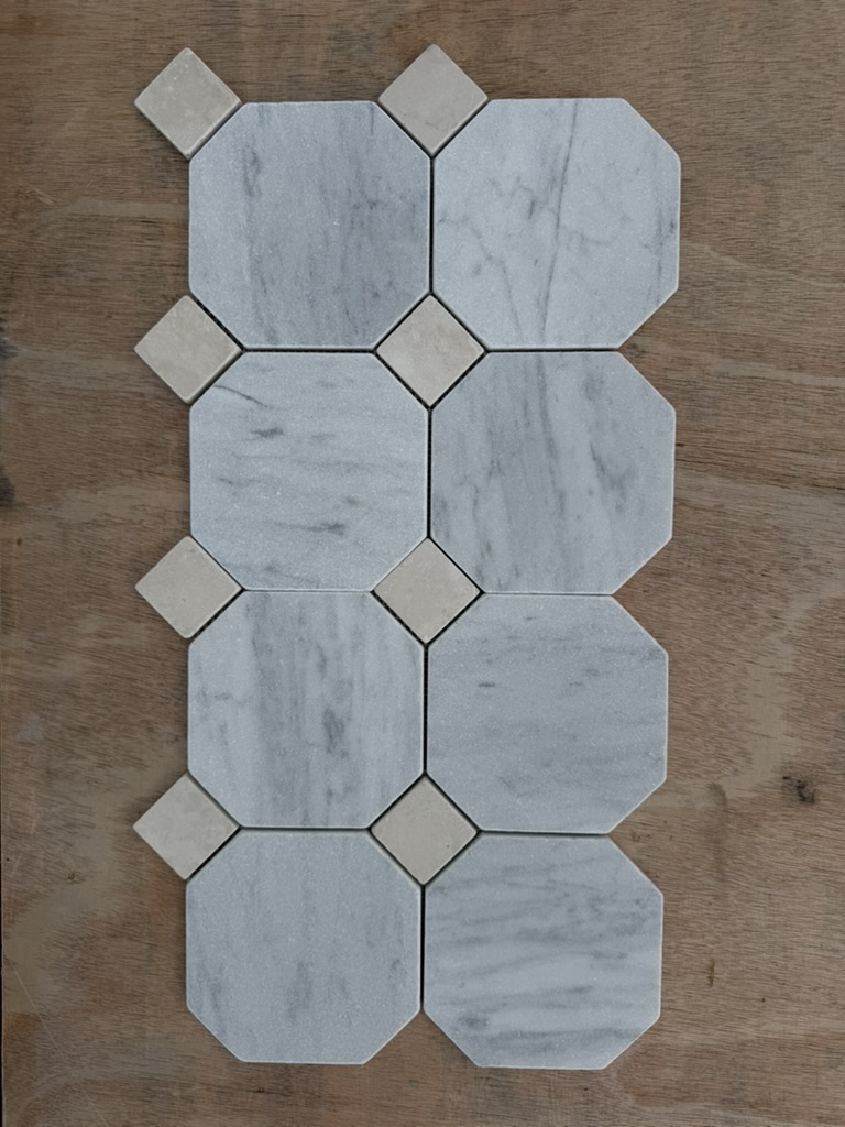 Marmorfliser i Ottagono Carrara med lett trumlet, antikk overflate og beige Botticino-tozzetti.